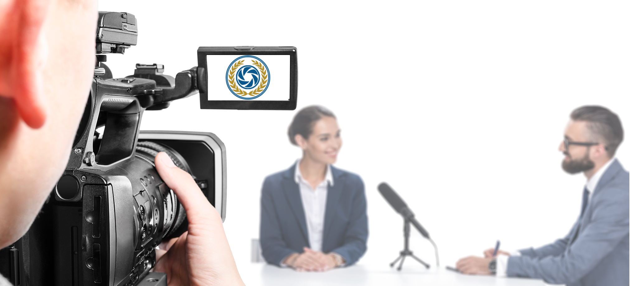 A videographer holding their camera up to record a witness talking to their lawyer in a deposition.